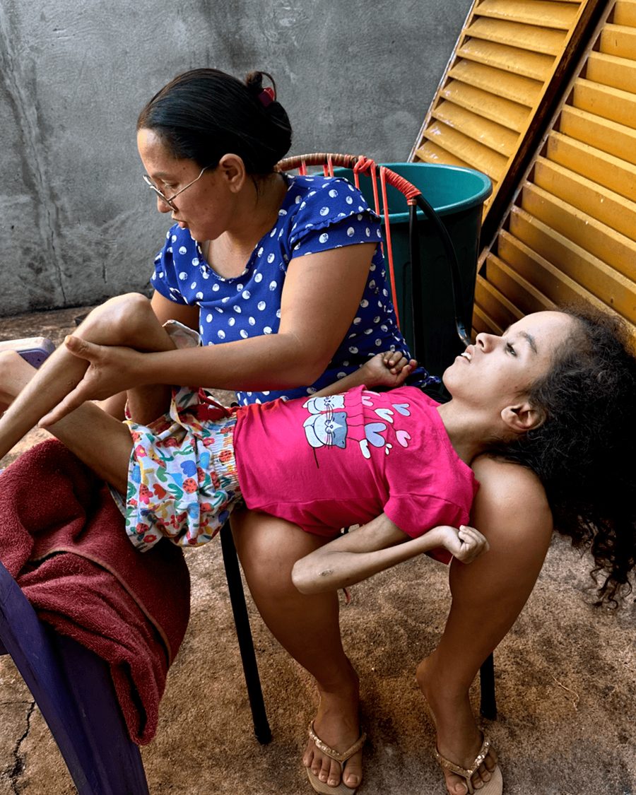 Maria Sônia dando comida a Ana Júlia na colher