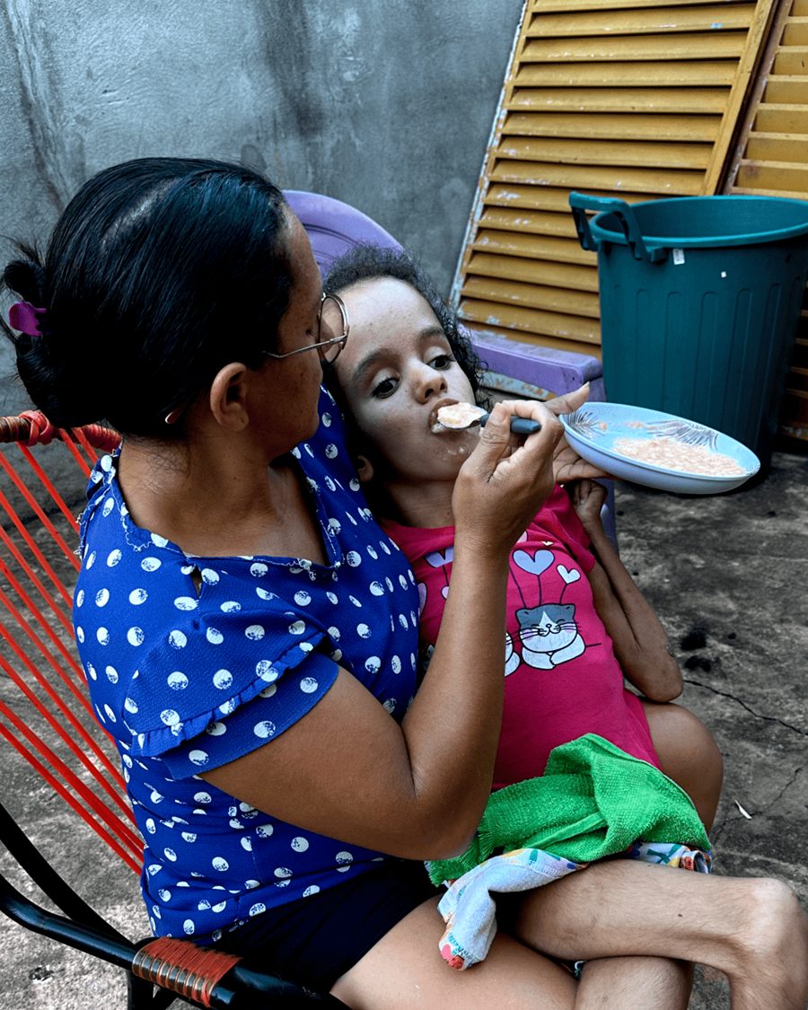 Ana Júlia sendo alimentada no colo